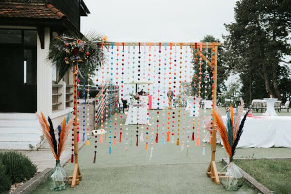 Une arche de pompons colorés pour une entrée de mariage originale par Esprit Pop'Up